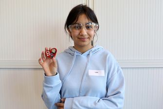 Mädchen mit Schutzbrille präsentiert gelötete platine in Herzform