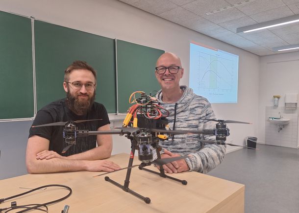 Student Malte Moersener hat sich in seiner Masterarbeit mit dem Aufbau der autonom fliegenden Drohne beschäftigt, die später die Pferdeäpfel identifizieren soll. Student Malte Moersener und Prof. Dr. Dietmar Gerhardt mit der Drohne.