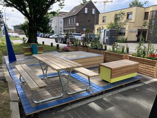 Eine Sitzgruppe mit Tisch auf einer rechteckigen Plattform am Straßenrand