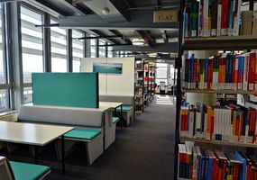 Fachbibliothek Wirtschaft: Blick aus den Regalen zu den Arbeitsplätzen