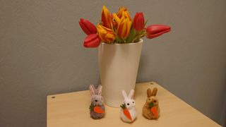 Eine Vase mit gelbroten Tulpen und Osterdekoration