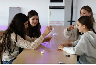 Vier Schülerinnen bauen Turm aus Spaghettis