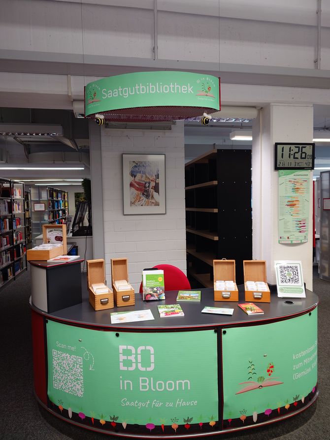 Blick auf die Saatgutbibliothek im Eingangsbereich der Fachbibliothek Technik mit den Saatgutkästen, passenden Büchern und Deko