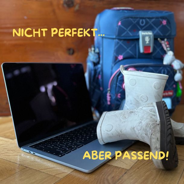 Laptop mit Kinder-Gummistiefel und einem Kinder-Rucksack
