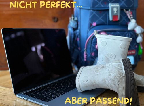 Laptop mit Kinder-Gummistiefel und einem Kinder-Rucksack