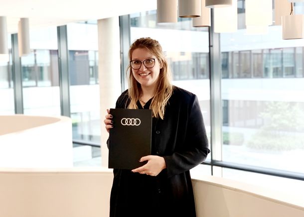 Xenia Wiedenmannott hält ihre Bachelorarbeit in der Hand.