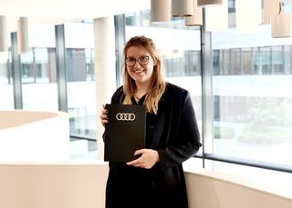 Xenia Wiedenmannott hält ihre Bachelorarbeit in der Hand.