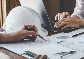 Construction and structure concept of engineer working drawing on blueprint meeting for project working with partner on model building and engineering tools in working site, construction concept