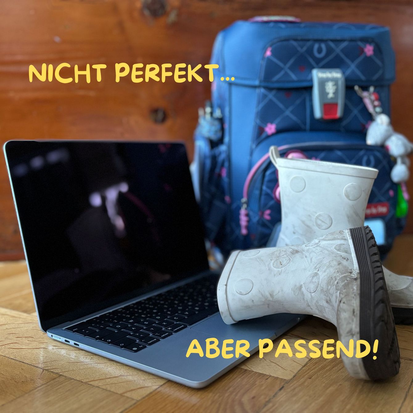 Ein Laptop mit Gummistiefeln und einem Kinderrucksack