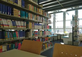 Fachbibliothek Wirtschaft: Blick aus den Regalen zu den Arbeitsplätzen
