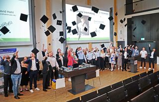 Fliegende Doktorhüte bei der Absolvent*innenfeier des Verbundstudiums 