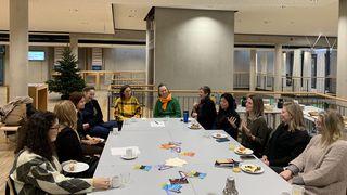 Foto vom ersten Meet&Eat Treffen. 11 Frauen sitzen an einem Tisch, während sie lachend einer Teilnehmerin zuhören