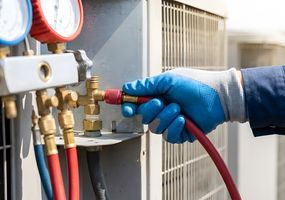 HVAC technician repairing air conditioning unit | checking refrigerant pressure with manifold gauges | professional AC maintenance and repair services | heating and cooling system diagnostic testing
