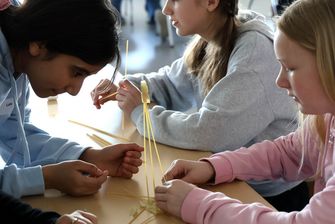 Schülerinnen bauen Turm aus Spaghettis