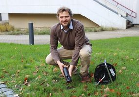 Prof. Dr. Bastian Welsch hält eine Tiefensonde in der Hand, mit der die Studierenden lernen zum Beispiel Temperaturmessungen in Bohrlöchern vorzunehmen.