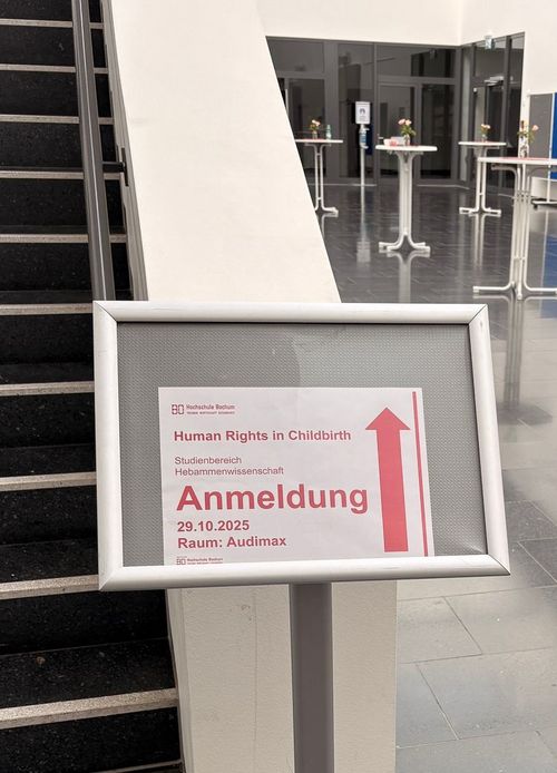 Schild mit Richtungsanweisung zur Anmeldung