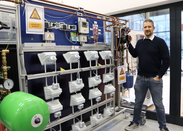 Prof. Dr. Rath zeigt an einem Lehrstand, dass die Studierenden sich auch mit der Integration von Photovoltaikanlagen und Solarthermie in Energienetze beschäftigen.