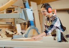 Tischlerin arbeitet mit Holz an der Tischsäge