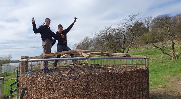 Zwei Studenten stehen auf dem Biomeiler.