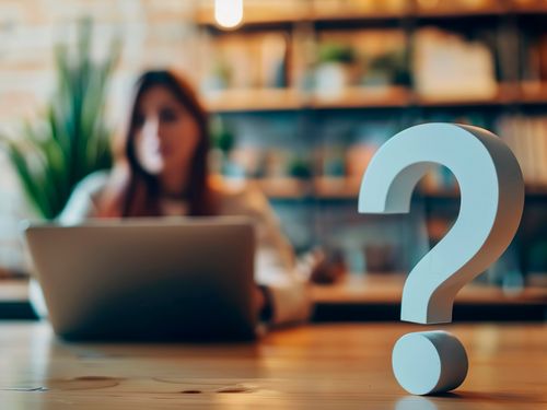 Fragezeichen mit verschwommener Frau im Hintergrund