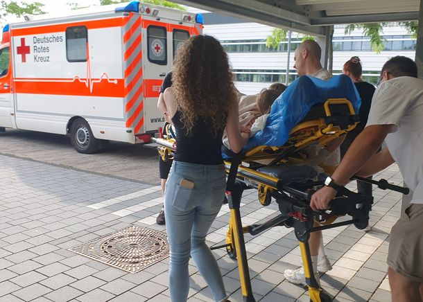 Gemeinsames Simulationstraining am Gesundheitscampus: Studierende des Masterstudiengangs Hebammenwissenschaft trainieren mit angehenden Notfallsanitätskräften die optimale Zusammenarbeit bei seltenen Geburtskomplikationen. Gemeinsames Simulationstraining am Gesundheitscampus: Studierende trainieren mit angehenden Notfallsanitätskräften die optimale Zusammenarbeit bei seltenen Geburtskomplikationen. Auf einer Fahrtrage wird die Gebärende zum Rettungswagen vor dem Hochschulgebäude gebracht.