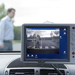 Bildschirm im Auto scannt einen Menschen, der über den Zebrastreifen vor ihm geht